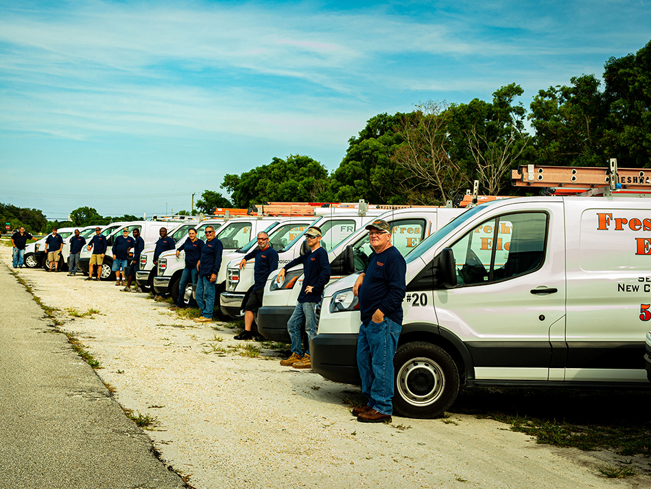 fleet of Freshwater electric vans with people standing in front of them