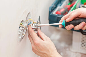 using screwdriver to work on Commercial Electrician and Electrical Contractor in Vero Beach, FL 